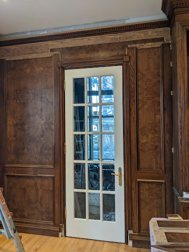 Photograph of the trim around the guest room door and panelling on either side.
